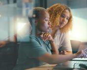 Two women working together on a computer