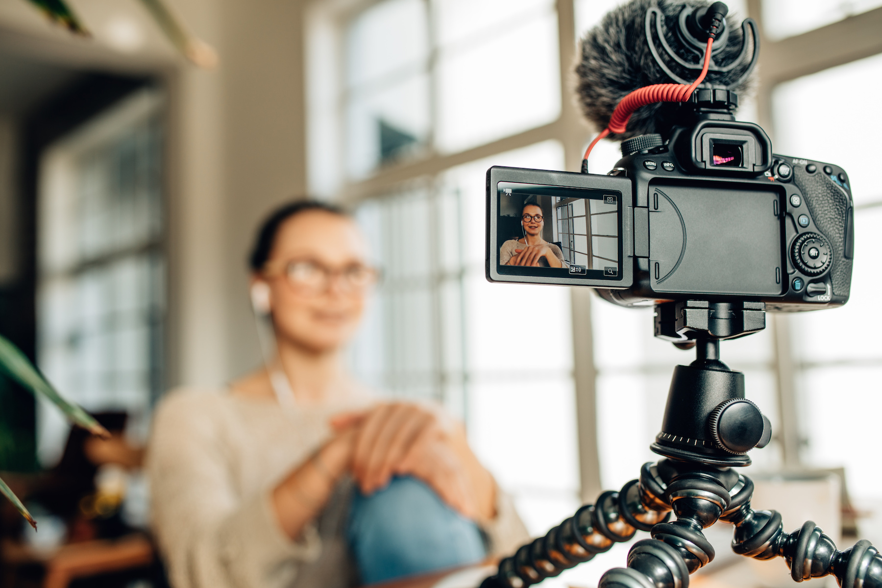 Blogger recording content for her blog on a camera mounted on flexible tripod.