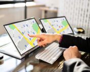 Person pointing at tablets with google maps displayed.