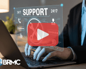 Person using laptop with words: SUPPORT and designs. Red play design and BRMC logo.