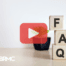 Wooden cubes with letters FAQ. Red play buttom overlay and BRMC logo.