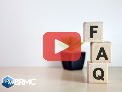 Wooden cubes with letters FAQ. Red play buttom overlay and BRMC logo.
