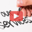 Person writing words, our services. Red play buttom overlay and BRMC logo.